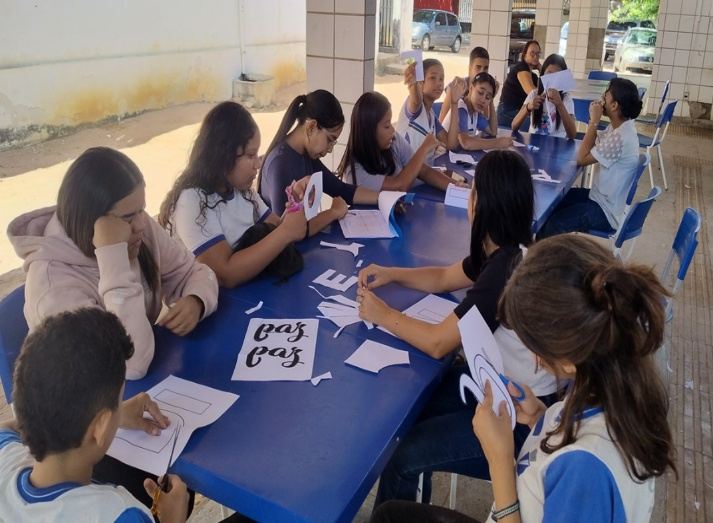 Estudantes em atividade prática com cartazes sobre a paz